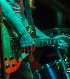 The guitarist plays on guitar in a dark room. Hands of a Guitar player playing the guitar. Low key 1385170622 bandsman